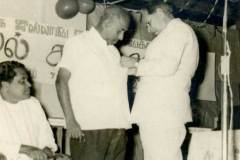 Azeez pinning the medal on Poet Abdul Cader Lebbe awarding him the title \'Kavignar     Thilakam\' (Poet par excellence).